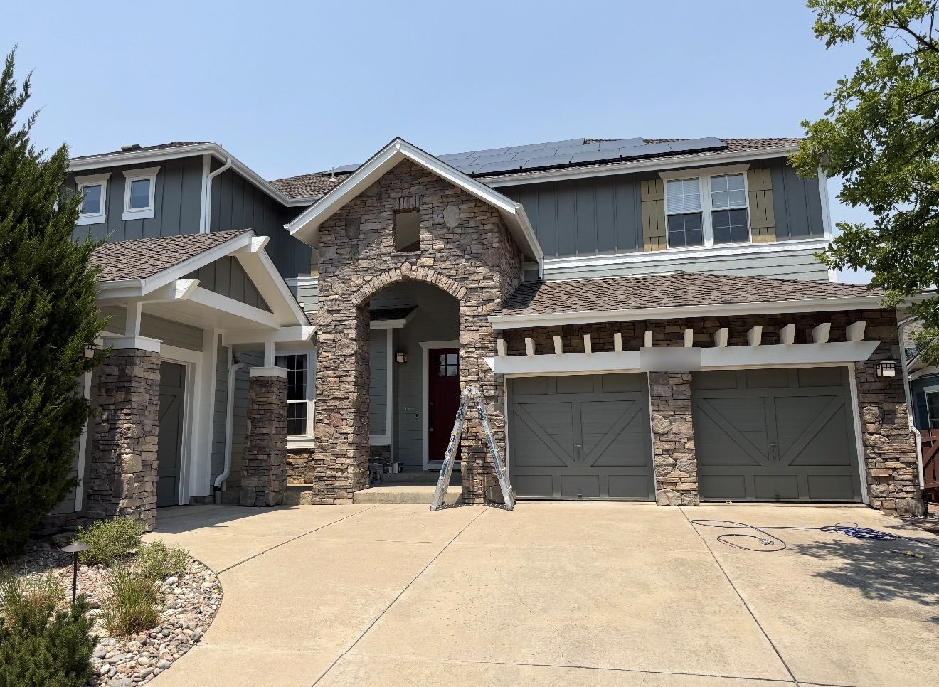 Craftsman home exterior with blue-gray siding, white trim and red front door