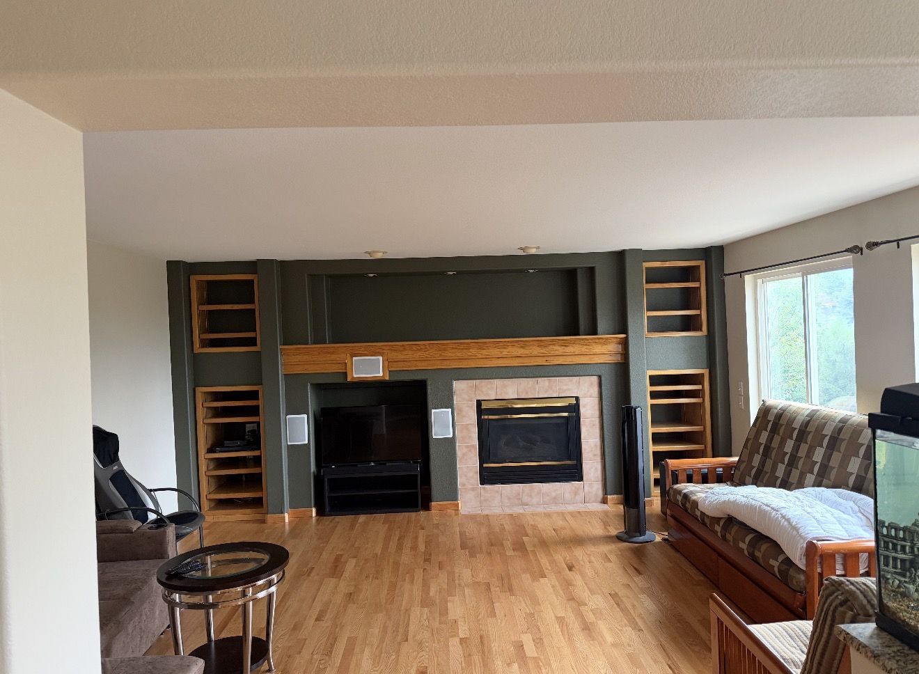 Family room with dark green accent wall around the fireplace