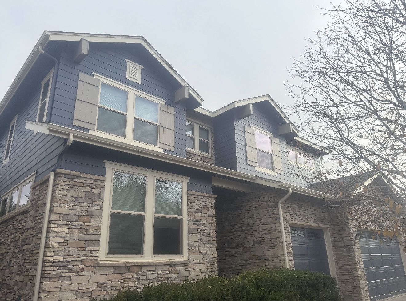 Side view of the repainted navy two-story home with taupe shutters